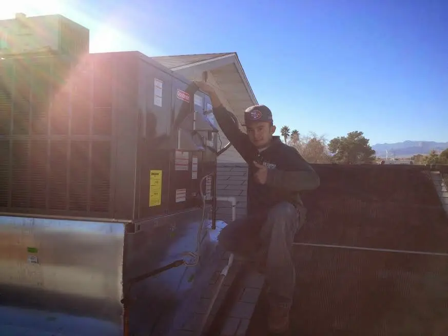 HVAC technician performing AC Tune-Up on a rooftop unit in Archbald
